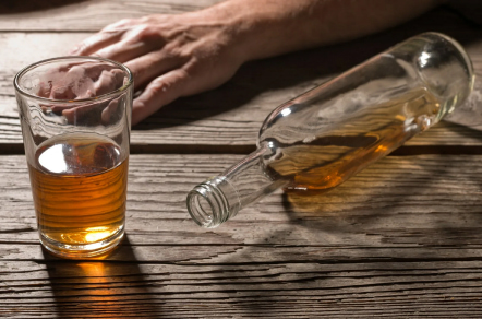 Бутылка и бокал с алкоголем на столе